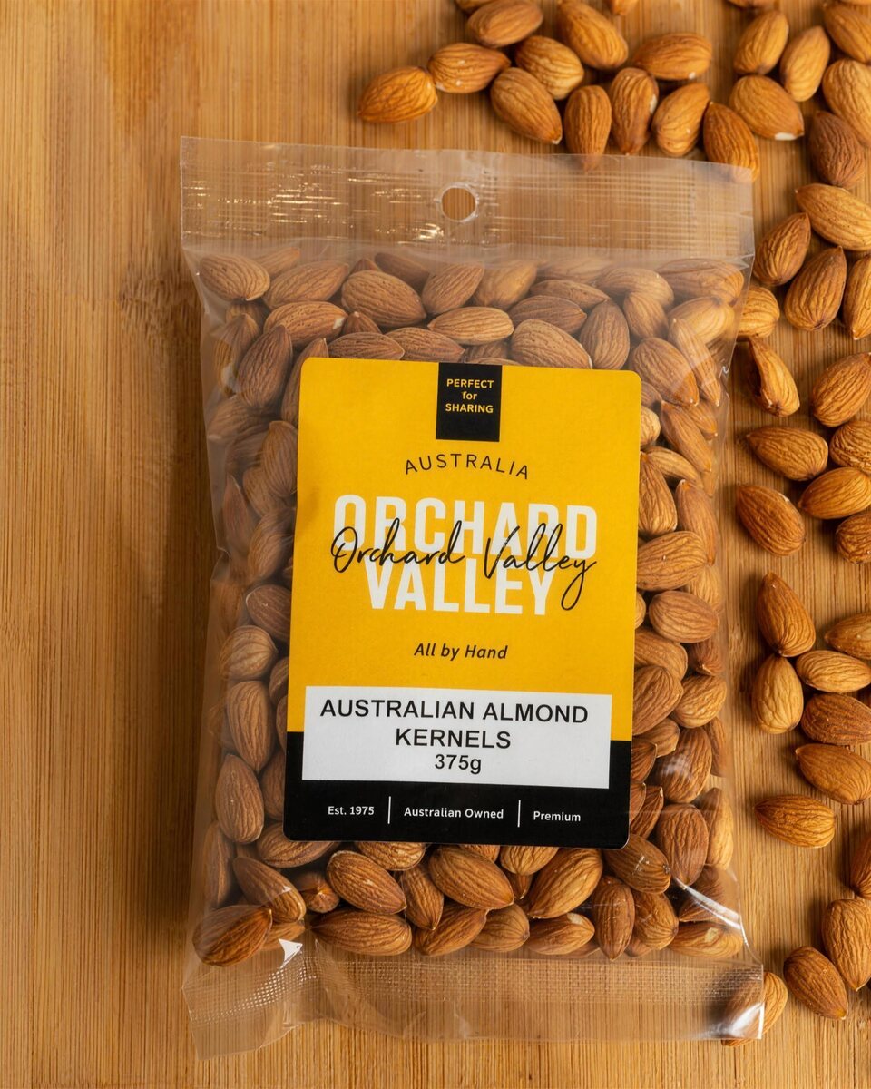 Orchard Valley Australian Almond Kernels 375g on a timber board with loose almonds.