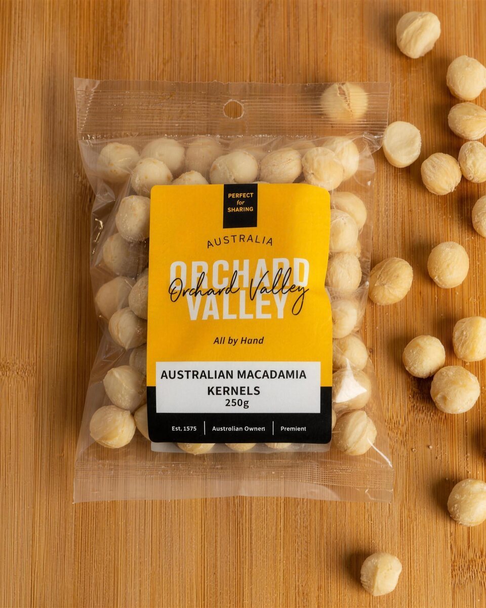 Orchard Valley Australian Macadamia Kernels 250g on a timber board with loose macadamias.